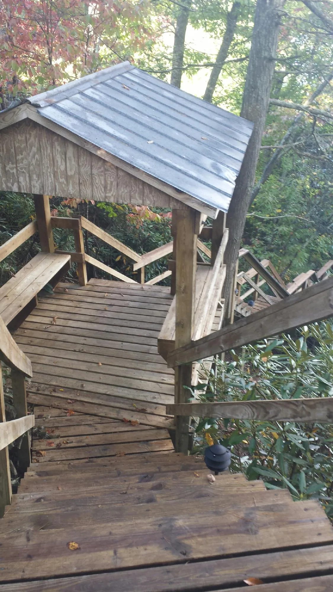 Metal roofed shelter over wooden steps on a wooded walkway — Skylight Repair & Installation work by our crew in Garards Fort