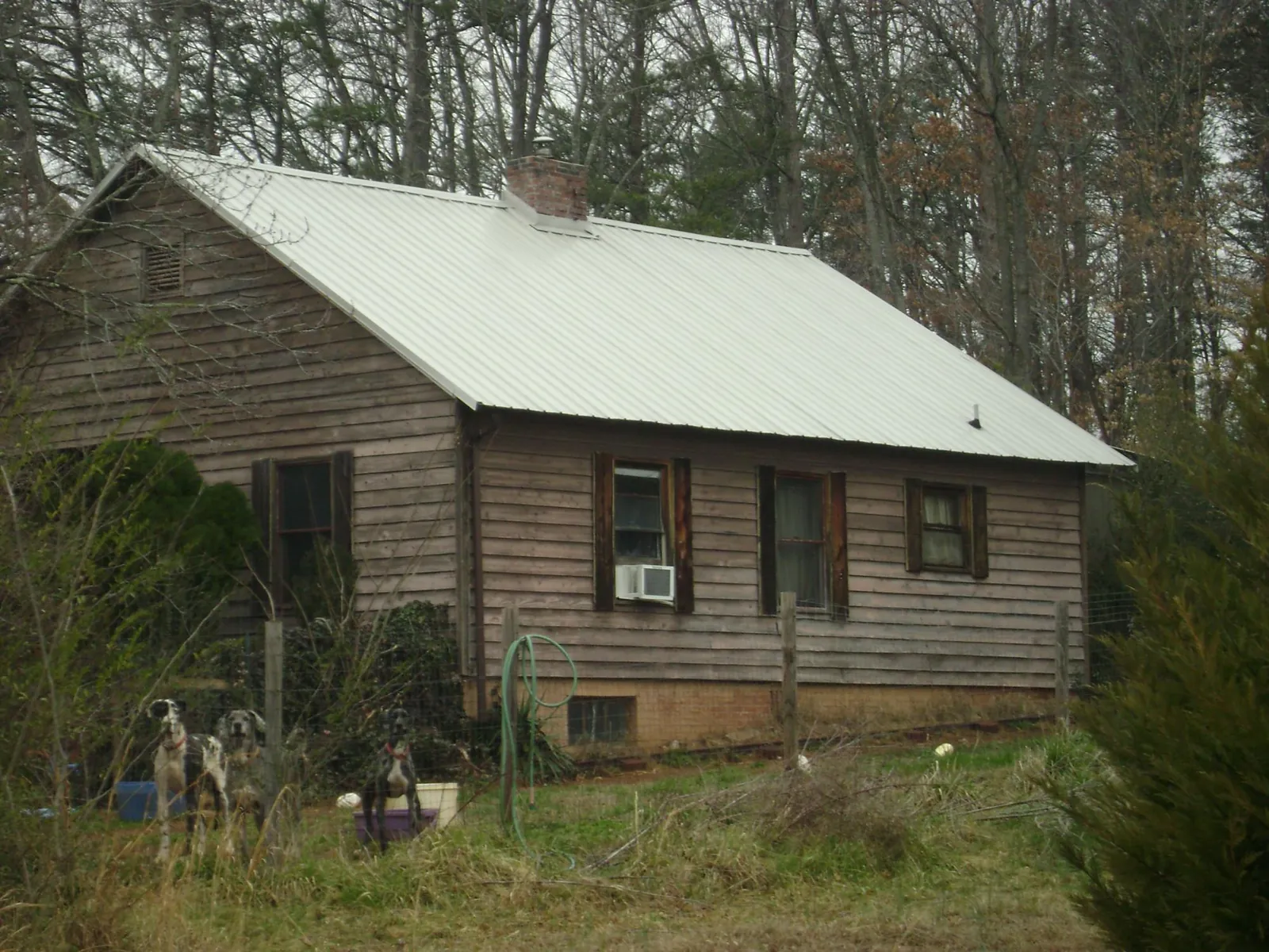 White metal roof on an old wood sided farmhouse, from a Metal Roof Installation job in Garards Fort